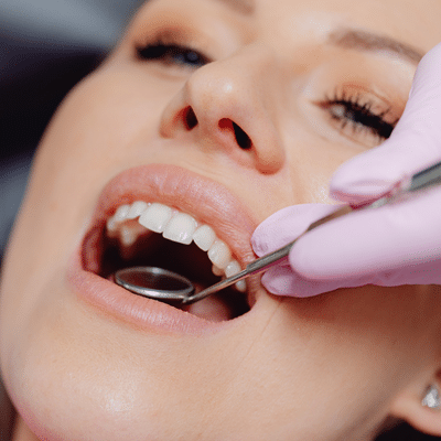 Woman getting teeth checked at the dentist, representing oral health and heart disease