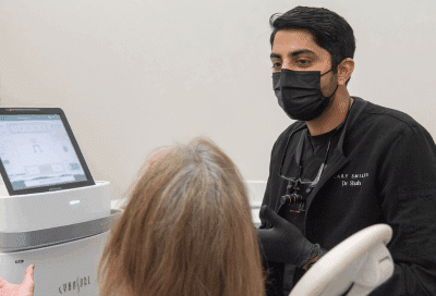 Dentist at cary smiles talking to a patient, representing veneers in cary nc