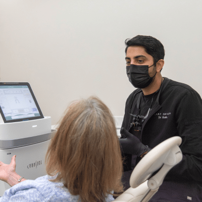 Dentist at cary smiles talking to a patient, representing veneers in cary nc