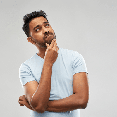 Thoughtful person in light blue shirt, representing common dental myths and misconceptions